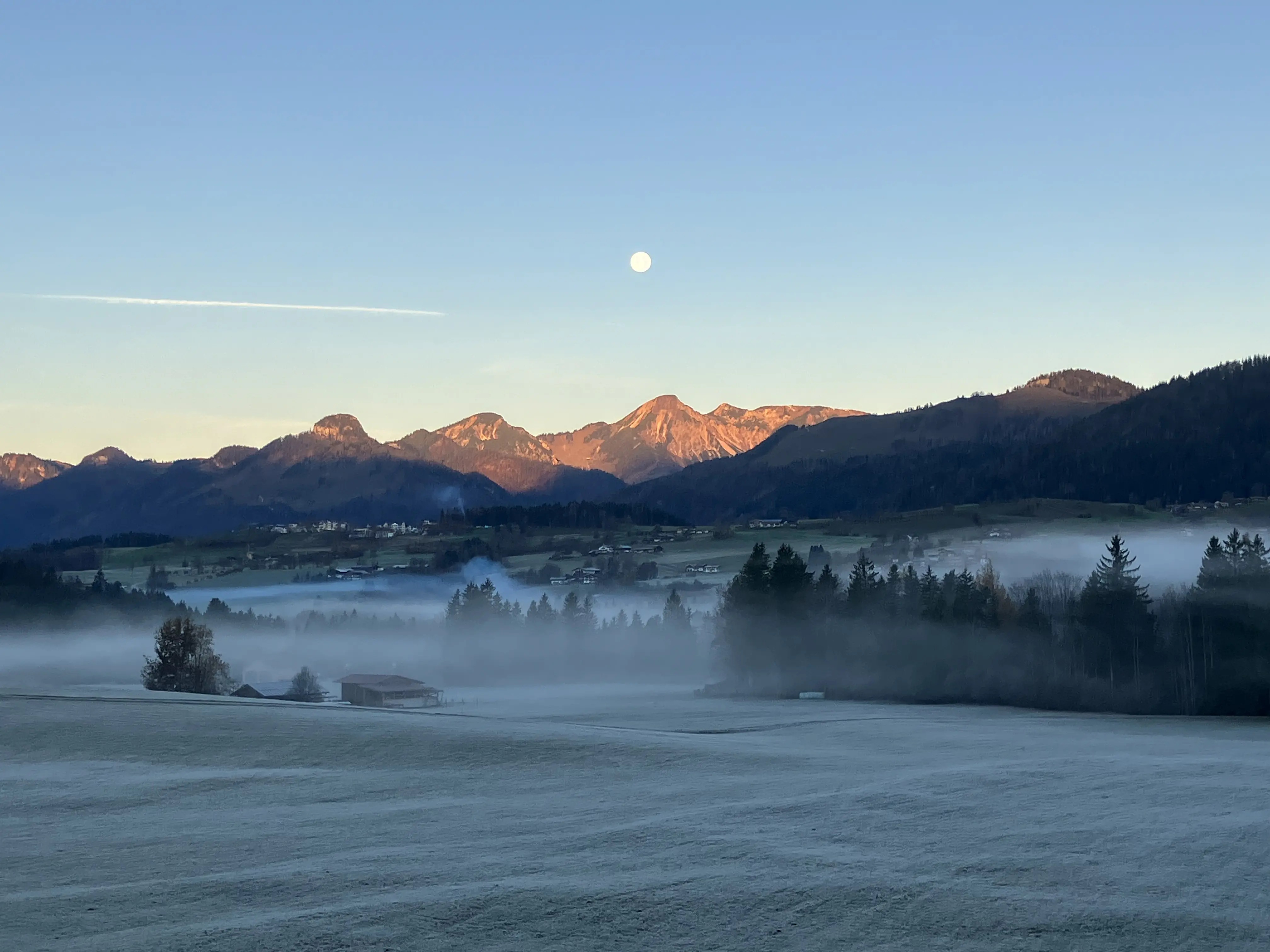 Sonnenaufgang mit Nebel über den Bergen bei Reit im Winkl